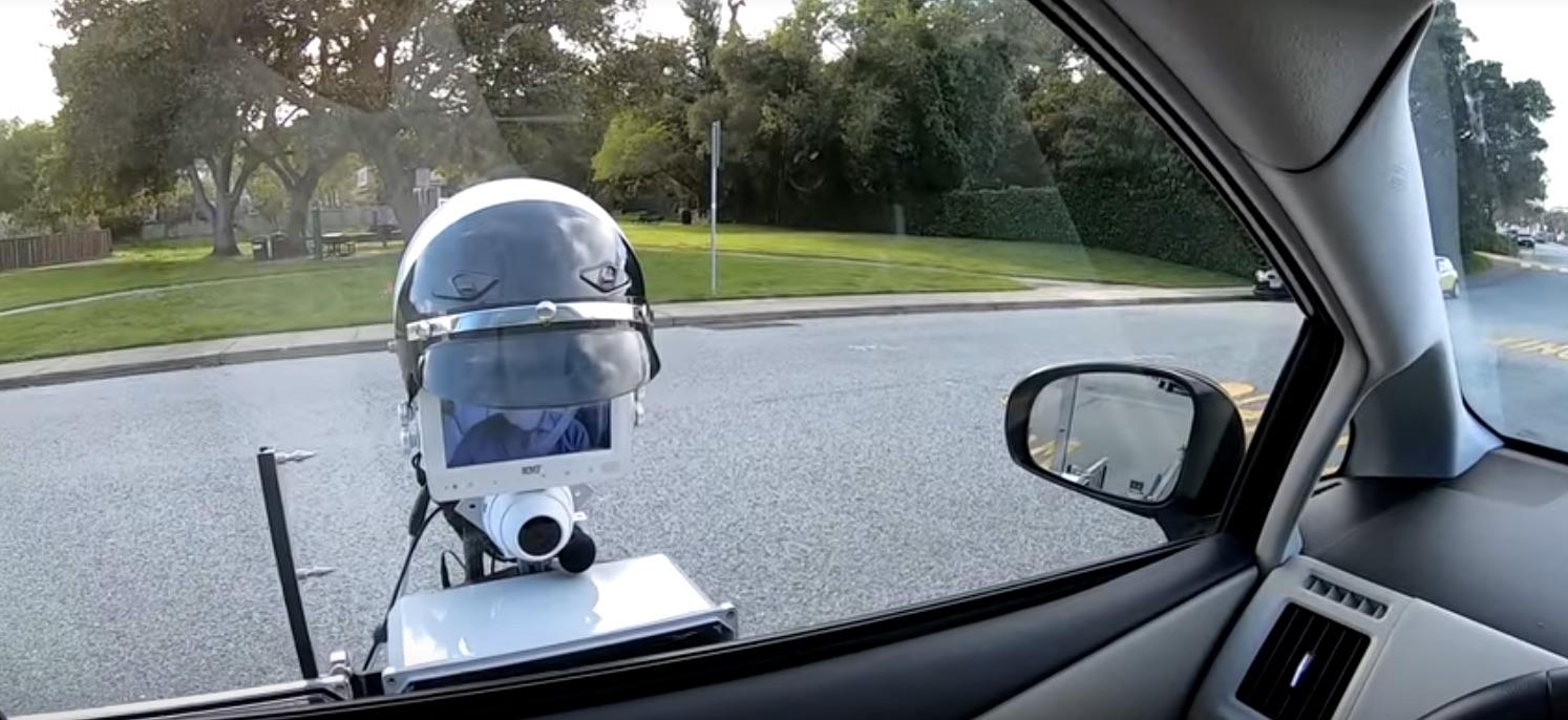 Prototipo del robot della polizia SRI International accanto a un'auto di pattuglia