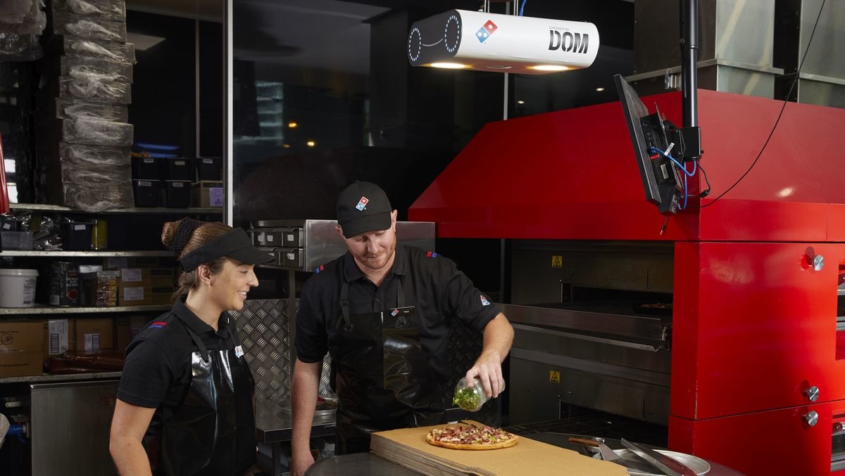Scanner DOM Pizza Checker installato sopra il banco di taglio delle pizze Domino's