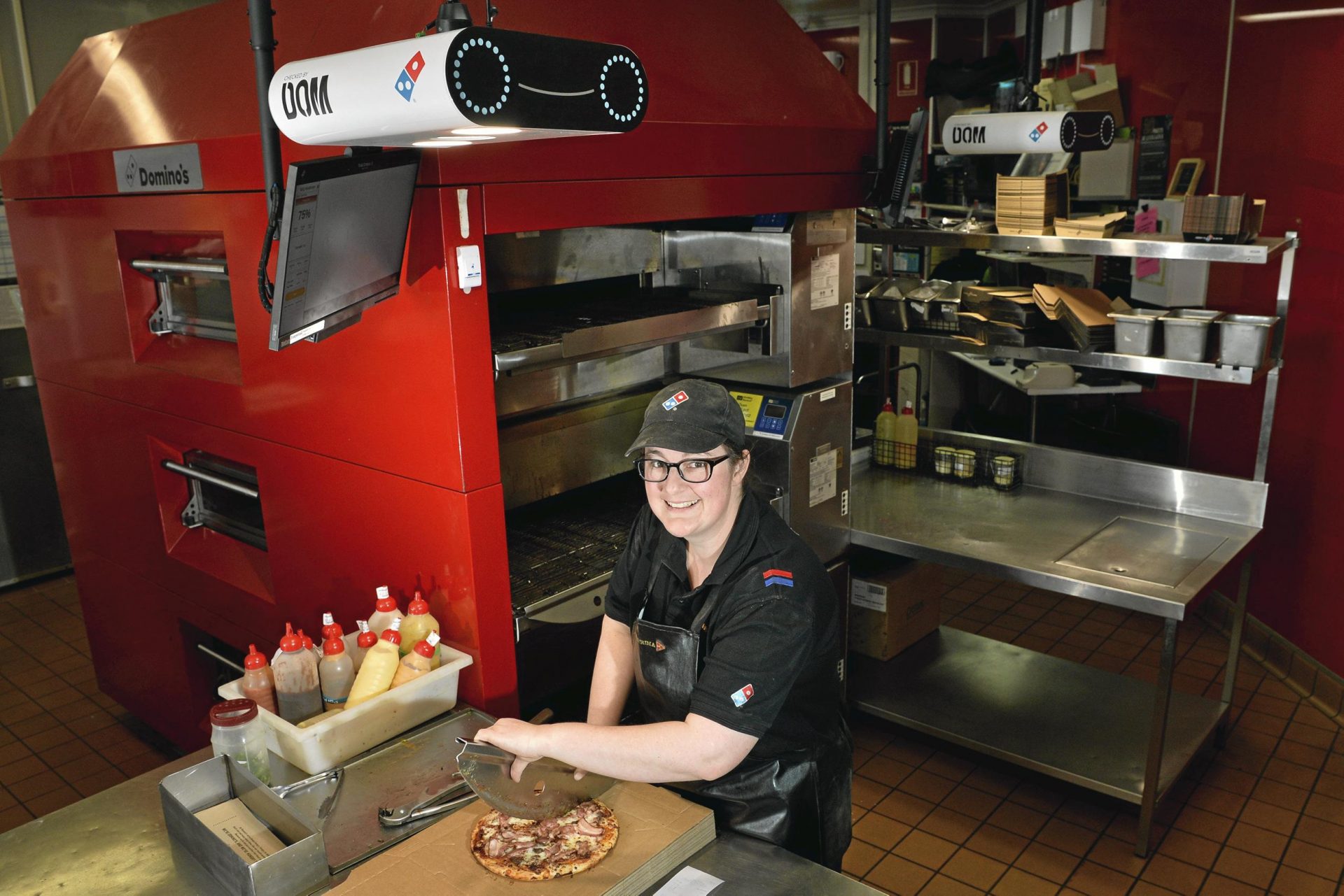 Katrina Copson, manager del punto vendita Domino's, accanto allo scanner DOM Pizza Checker